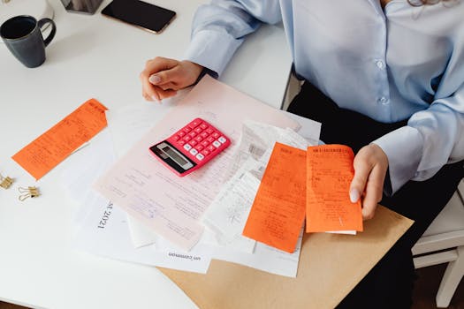 person reviewing documents with calculator