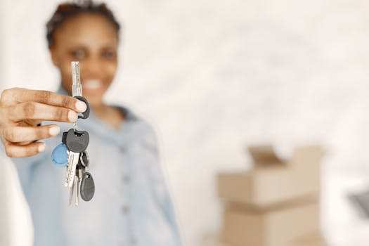 A person holding house keys with a calculator