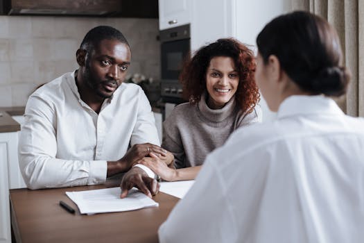 a couple sitting at a table with a laptop, reviewing their finances